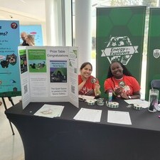 two volunteers sitting at the prize booth table