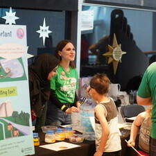 a volunteer talks to guests about her research