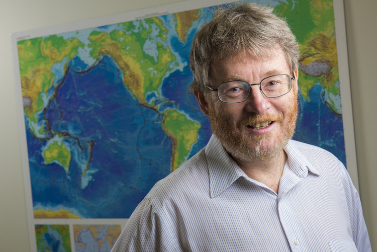 Professor and geophysicist Martin Unsworth stands in front of a map of Earth's Ring of Fire, a region of volcanoes circling the Pacific Ocean. Photo credit: John Ulan