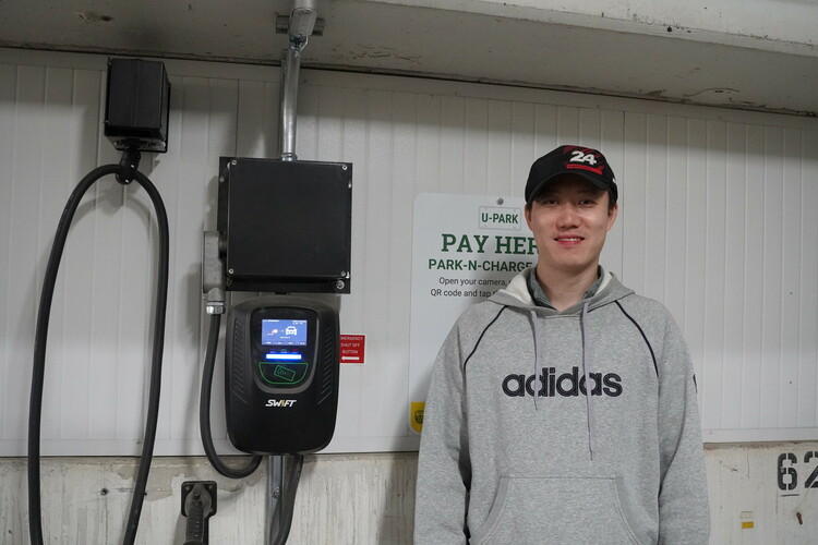 Zhongyi Quan next to his Swift Charge EV charger