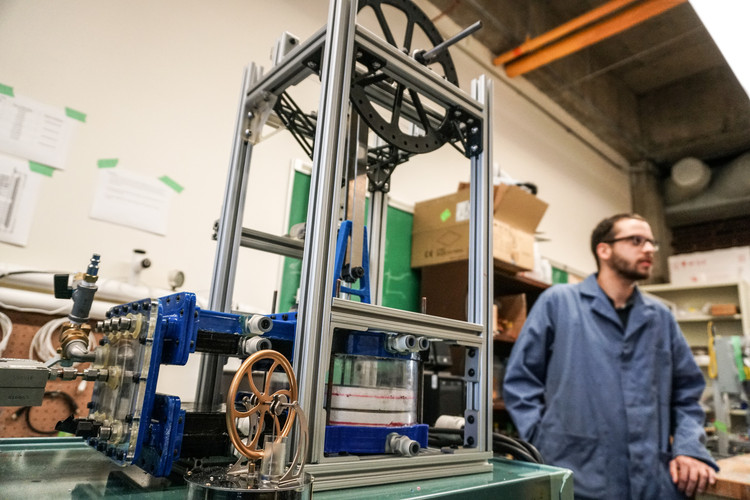 Masters student Jason Michaud with a gamma-type ultra-low temperature differential Stirling engine built by graduate students for testing as part of a Future Energy Systems geothermal energy project.