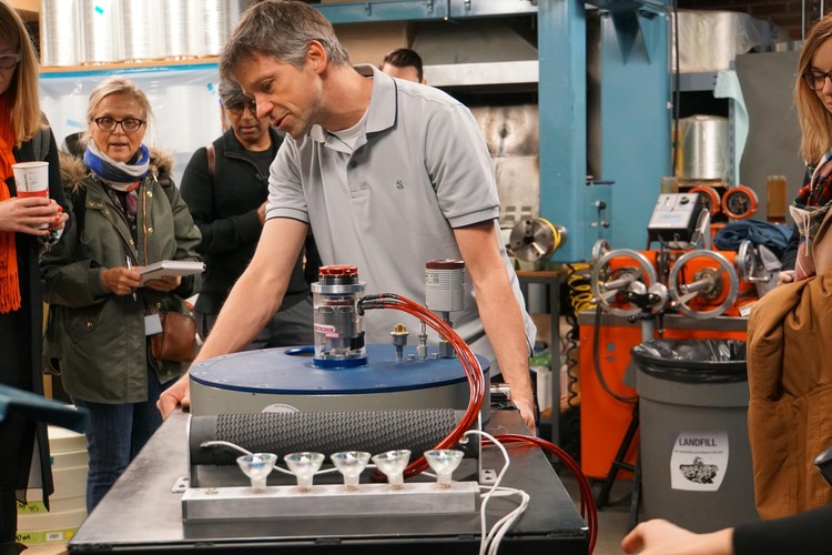 Principal Investigator Pierre Mertiny welcomes a tour group to his lab.