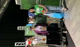 FES grad students pose for a photo in front of a future energy systems banner