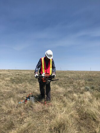 Jingchuan stands in a field with seismic equipment