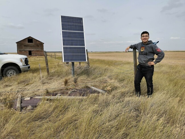 Dr. Jingchuan Wang next to a solar cell