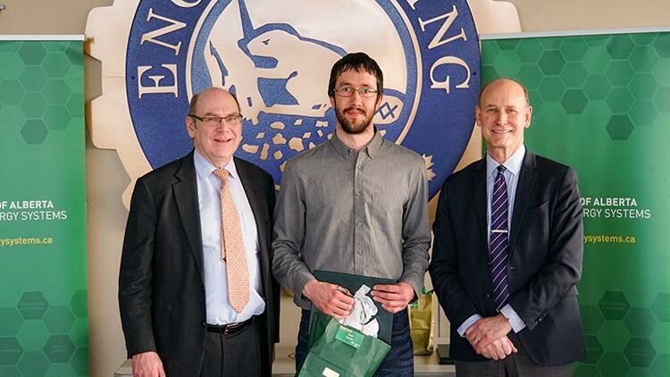 Three men, Michael in middle holding an award.