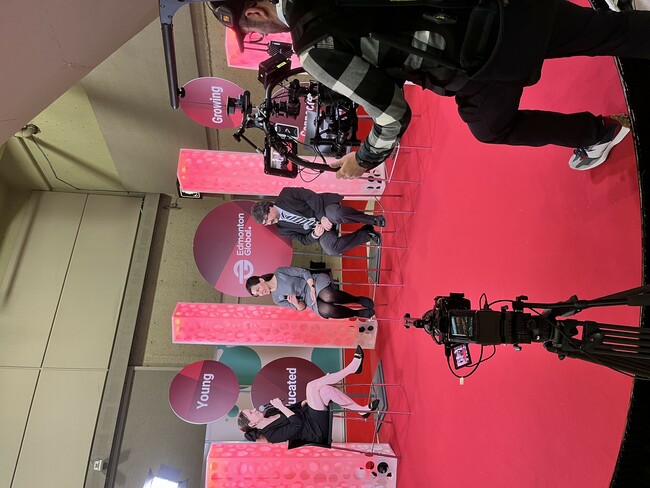 BTS photo of Dr. Shiva Mohajernia and Dr. Amit Kumar speak to Kessia Kopecky of Edmonton Global