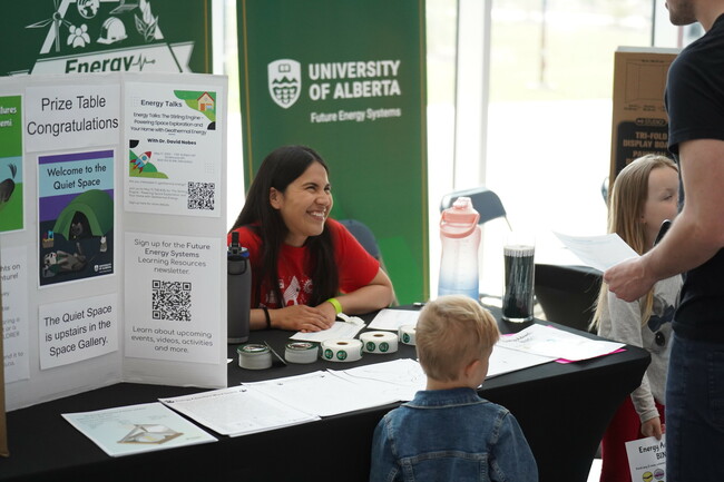 Science Rendezvous volunteer Maria hands out prizes at the prize table